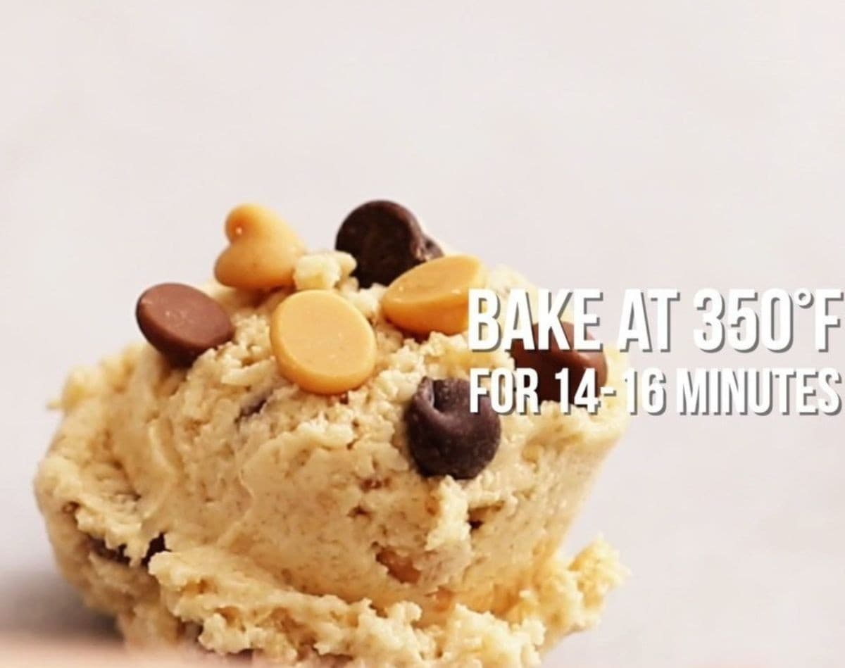 Chocolate and peanut butter chips being added to the portioned dough.