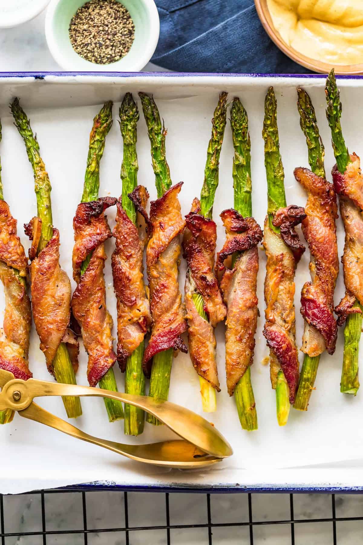 Bacon Wrapped Asparagus baked on a white tray