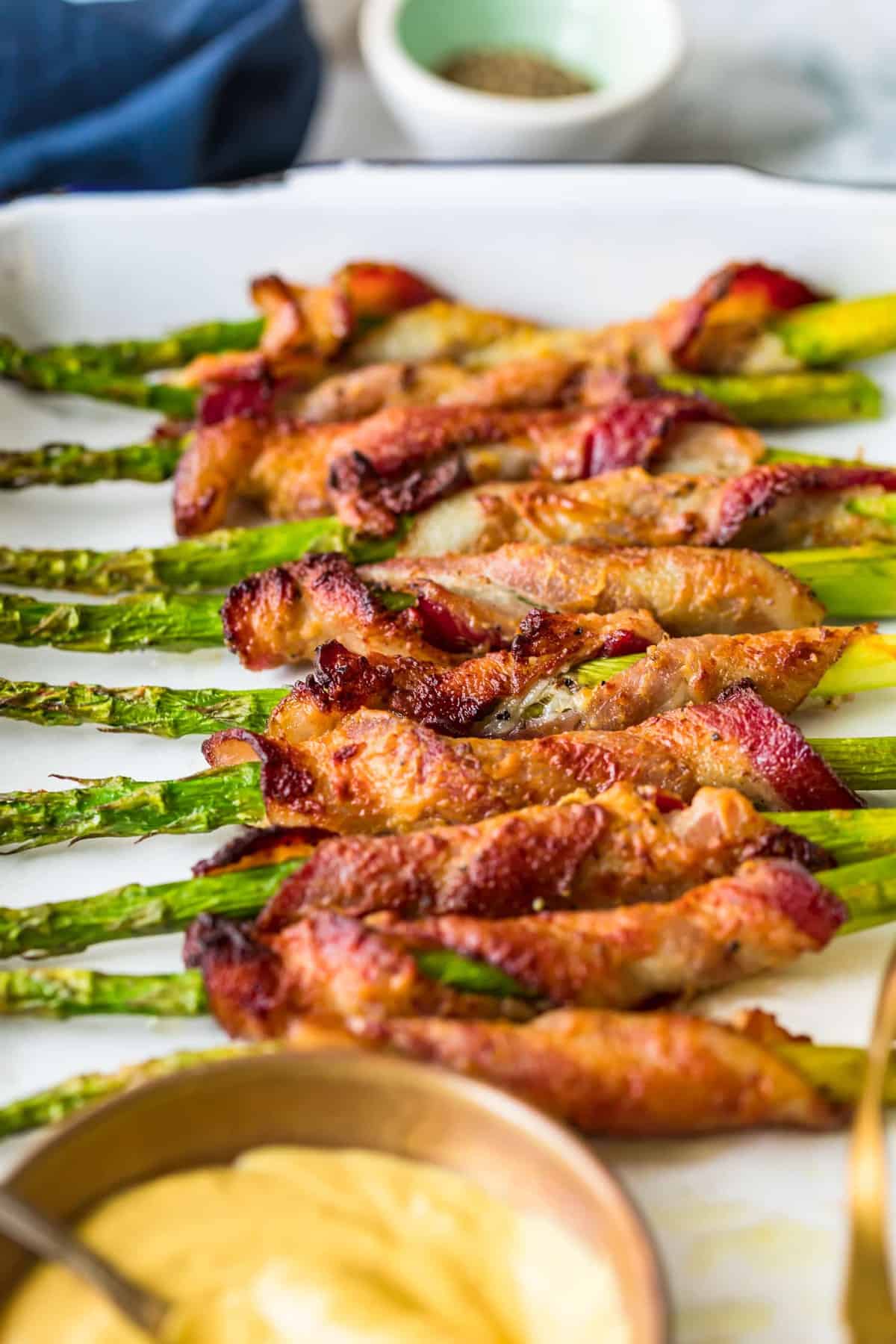 Bacon Wrapped Asparagus in a row on a white plate