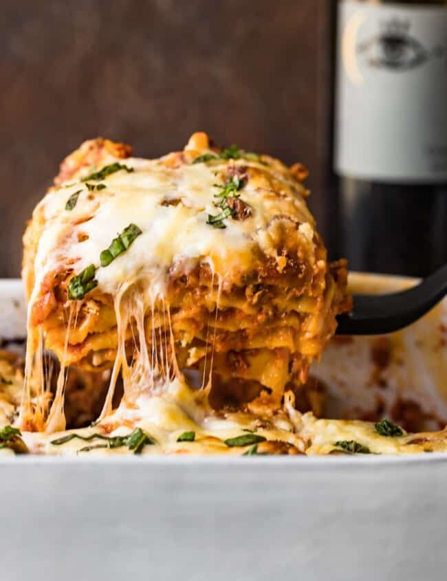 cheesy lasagna coming out of baking dish