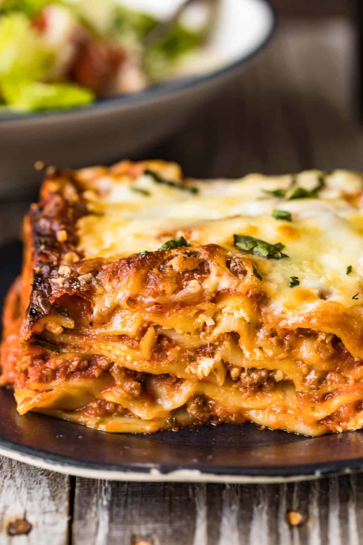 A square of Lasagna with Meat Sauce served on a dark blue plate