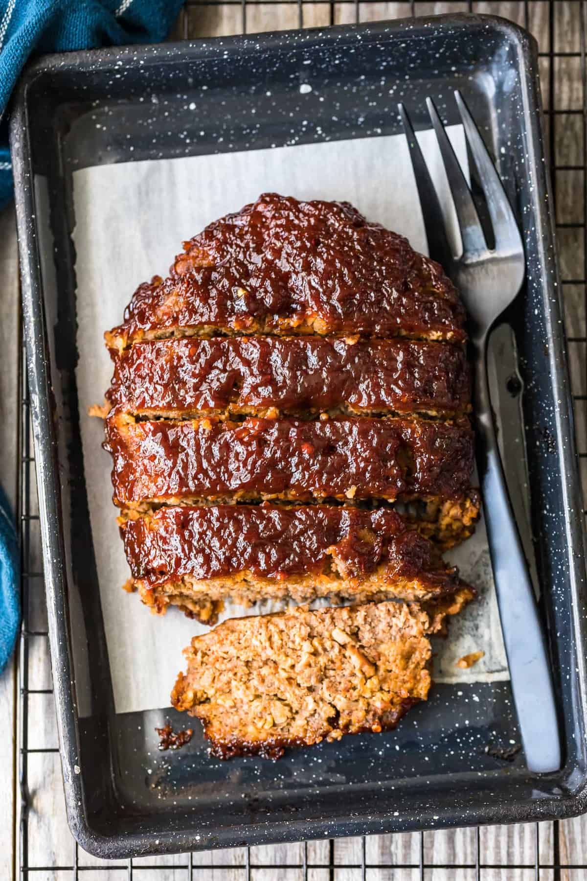 Top shot of Bacon Meatloaf cut into slices on a black tray
