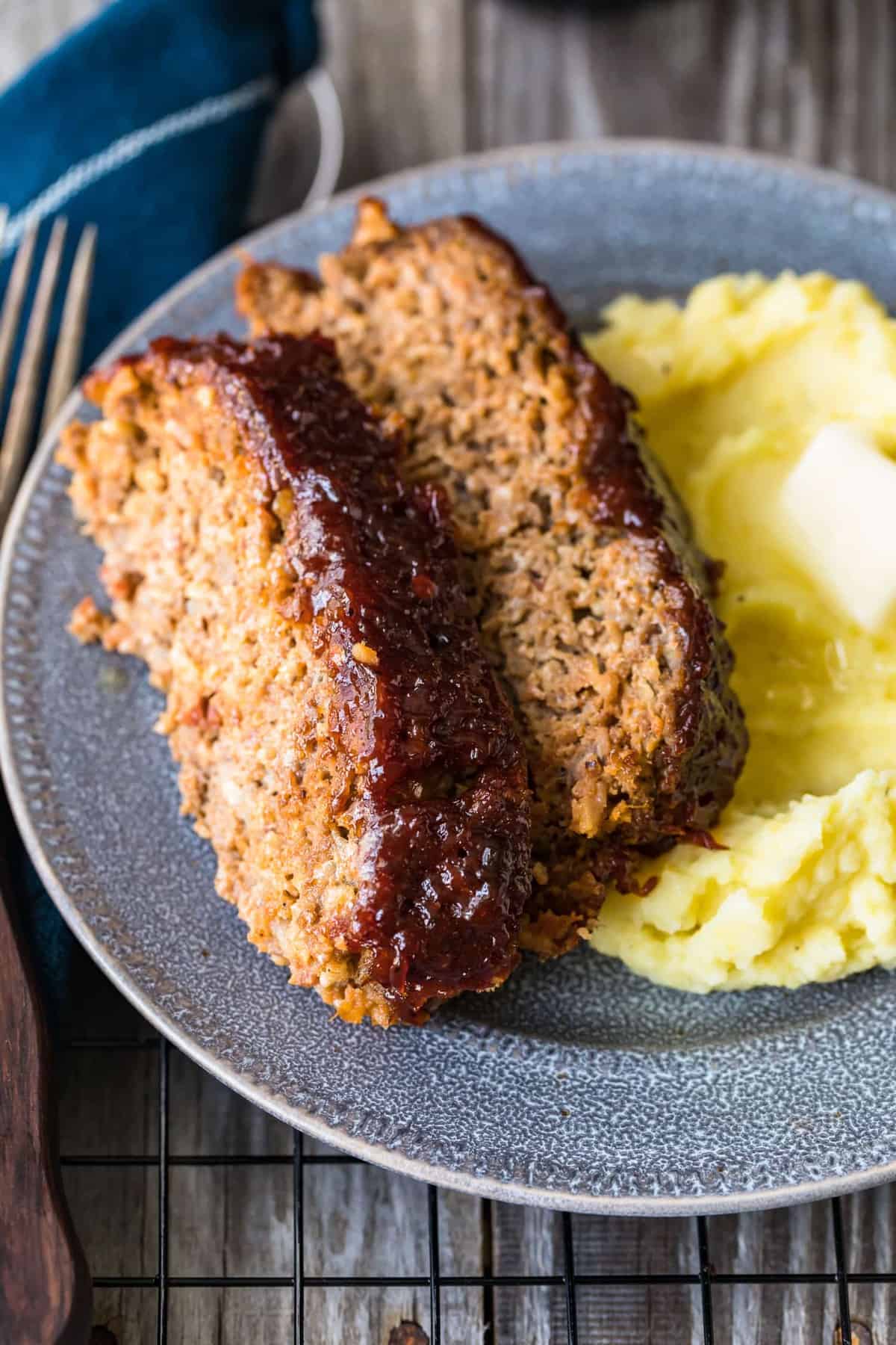 Meatloaf served on a blue plate with mashed potatoes