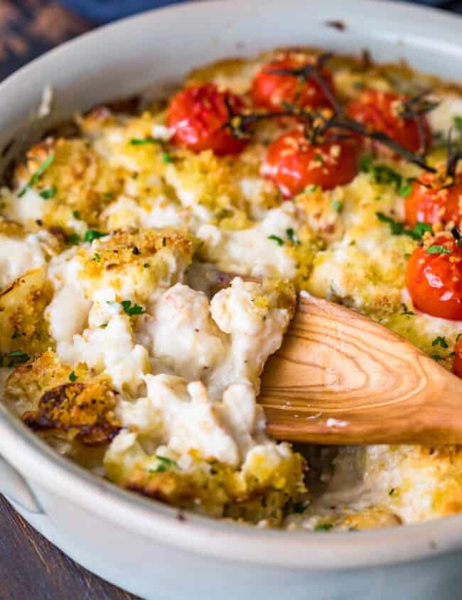 cheesy cauliflower au gratin in dish with wooden spoon