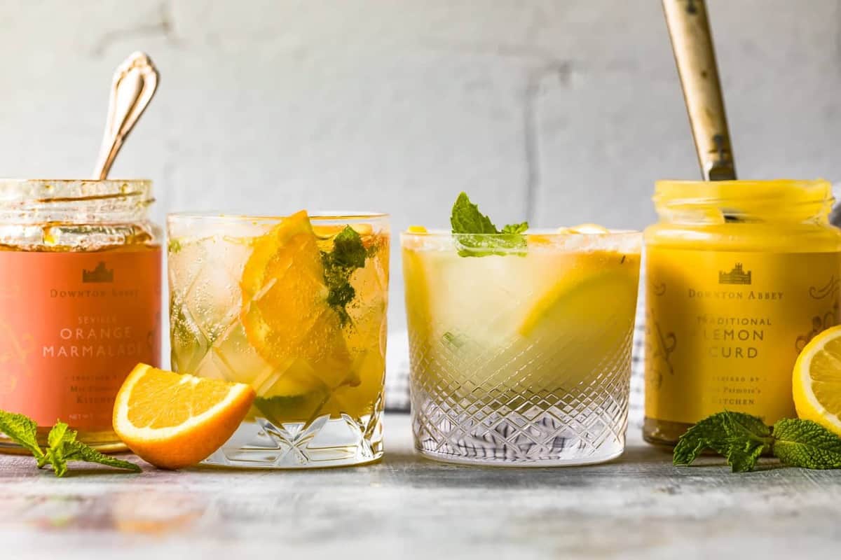 orange marmalade and lemon curd in jars on a table next to citrus smash cocktails