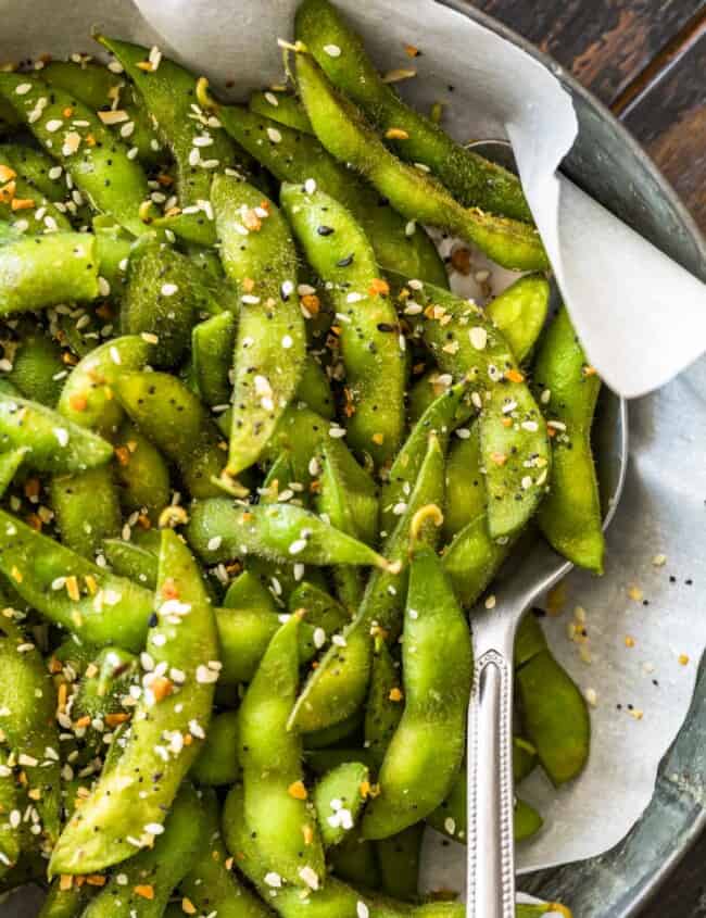 Bright green edamame in a bowl seasoned with a spoon