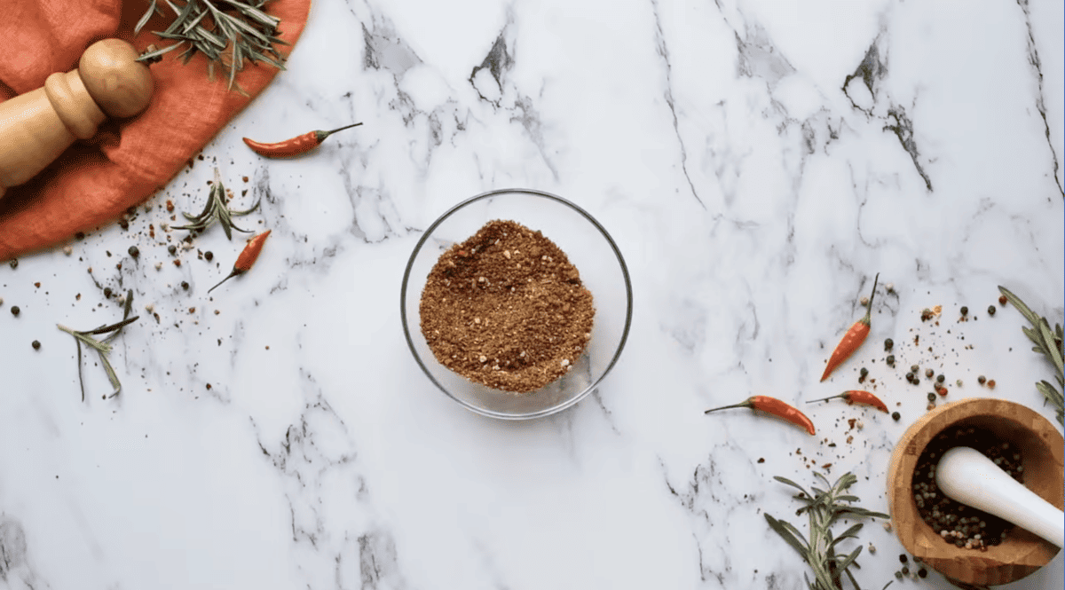 A bowl of Homemade Fajita Seasoning on a marble table.