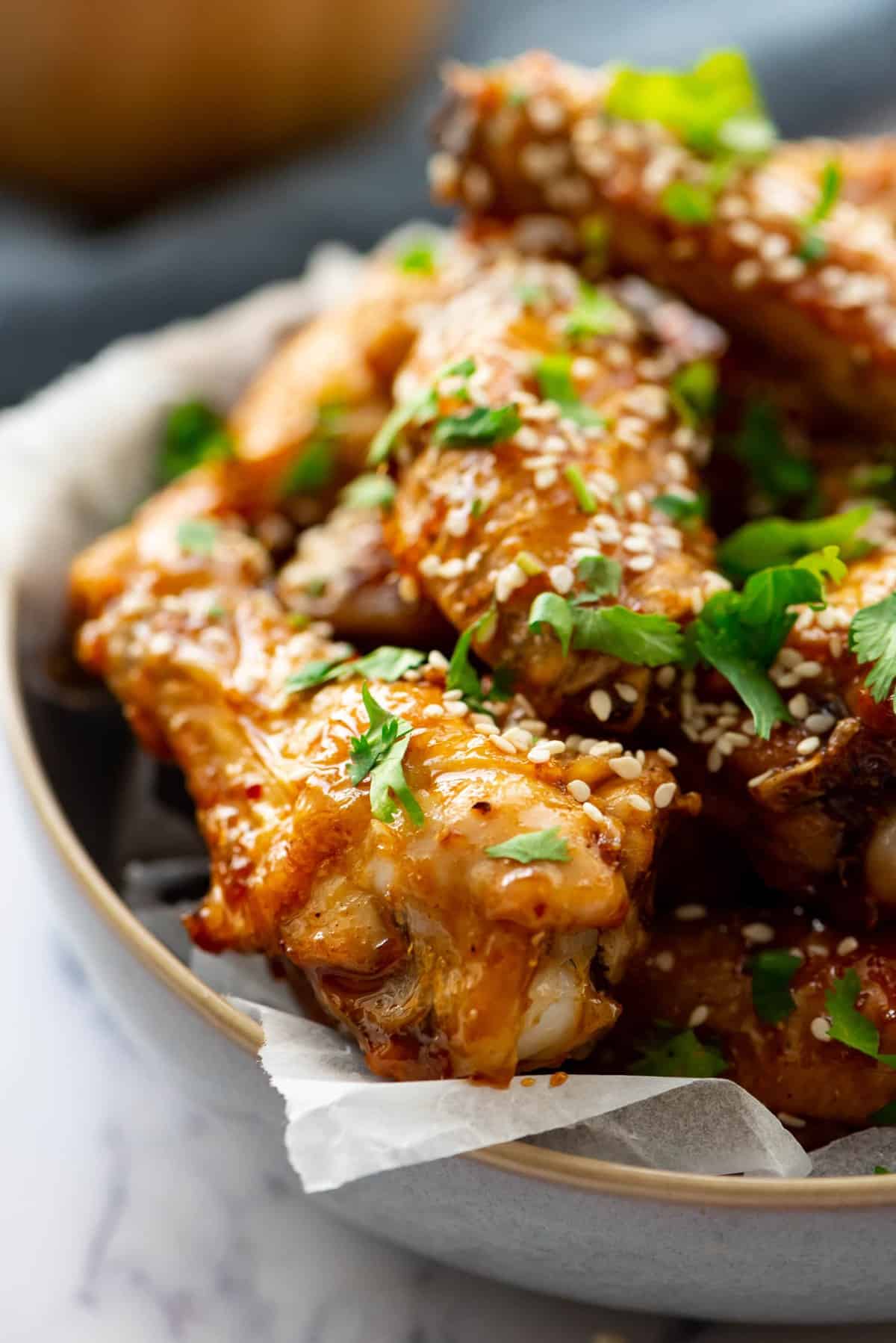 Honey Glazed Chicken Wings garnished with herbs and white seeds