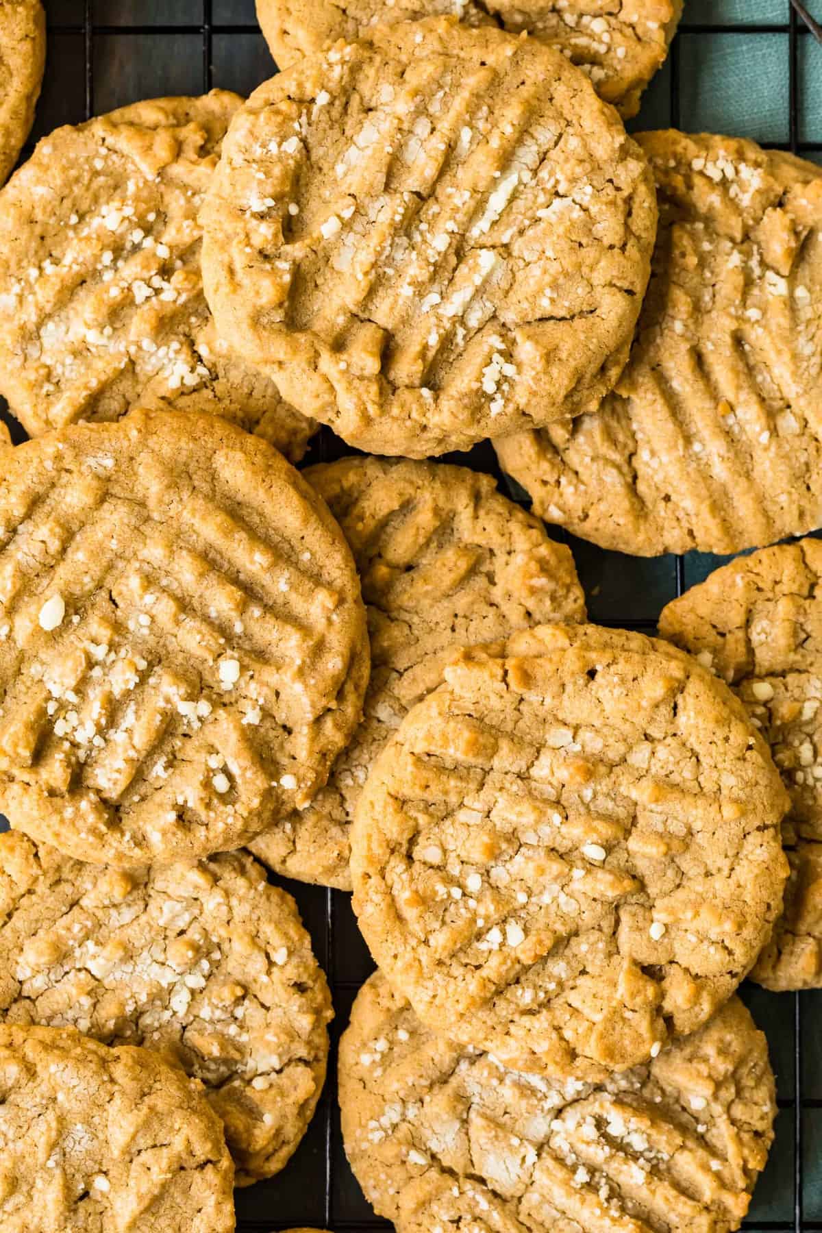 A pile of peanut butter cookies on a cooling rack