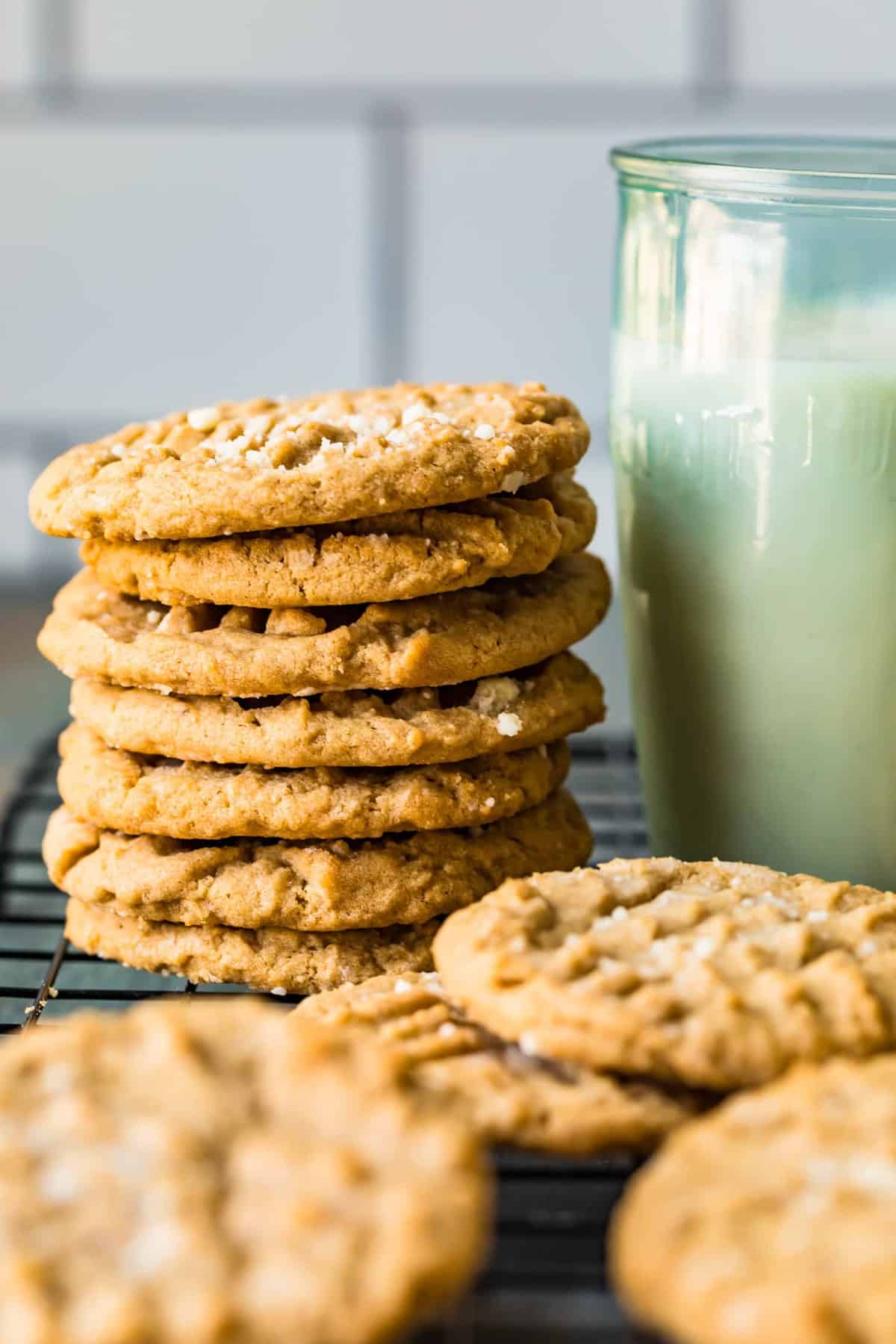 A stack of peanut butter cookies next to a glass of milk