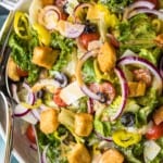 a salad full of veggies, dressing, and croutons