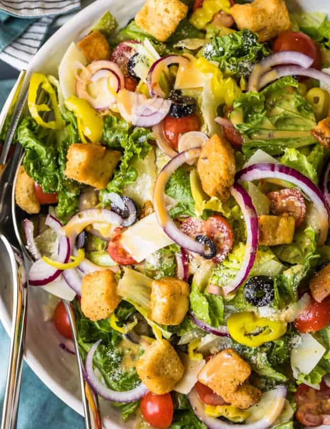 a salad full of veggies, dressing, and croutons