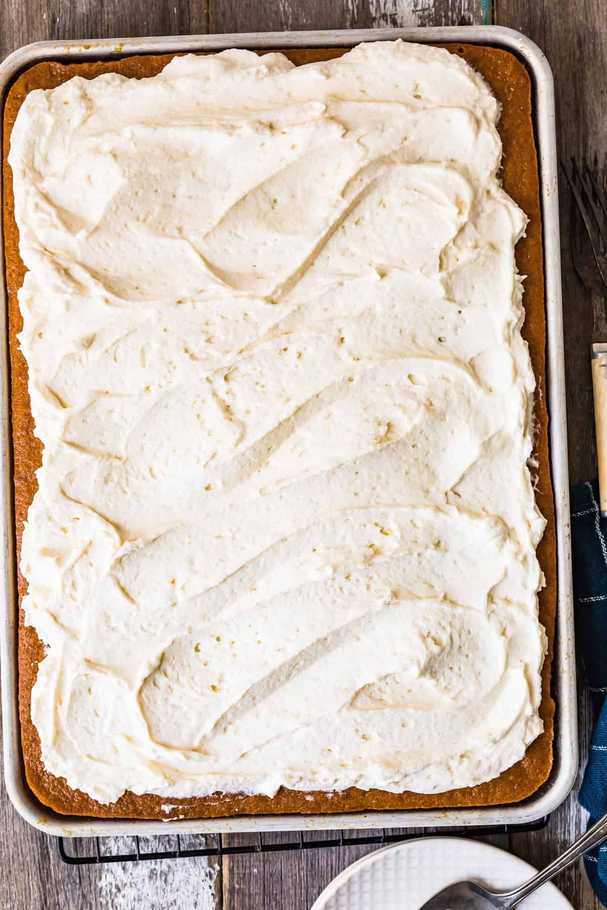 Frosting spread over the cake in a pan