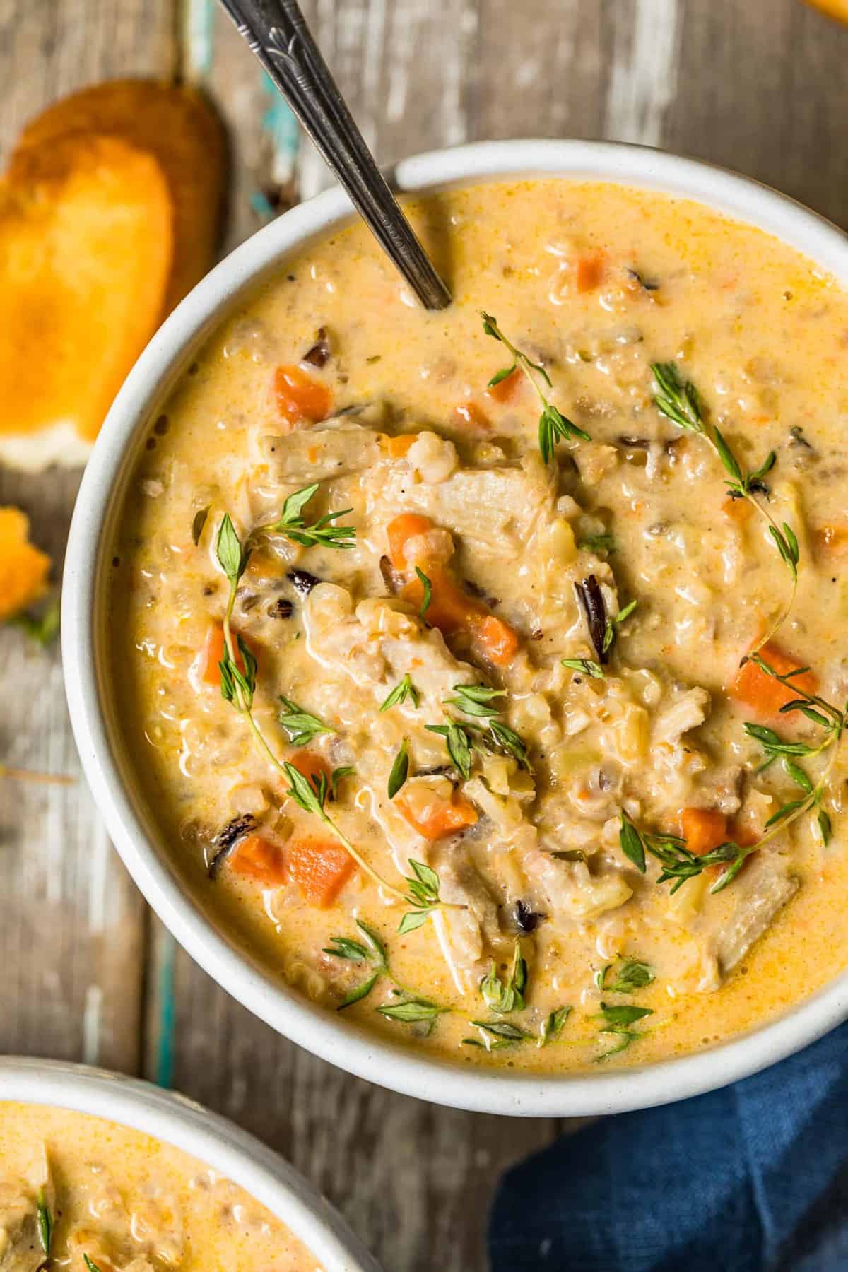 Close up of turkey wild rice soup in a white bowl with a spoon