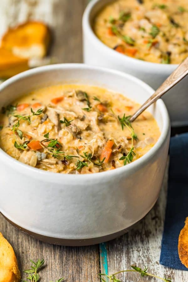 Two bowls of leftover turkey soup on a wooden table.