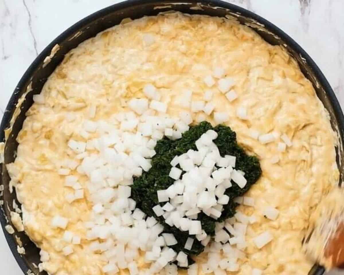 Adding spinach and chopped water chestnuts to the mixture.