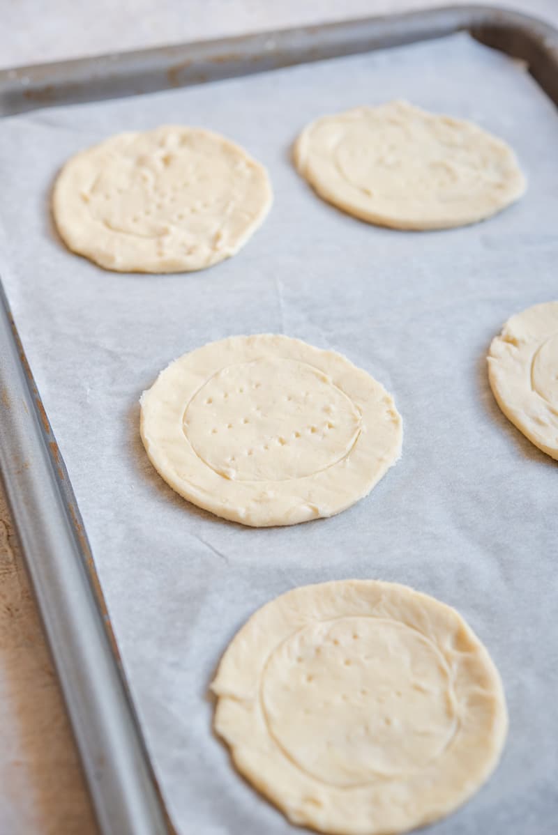 A close-up view of pastry circles on a baking tray for making Mini Caprese Tarts.