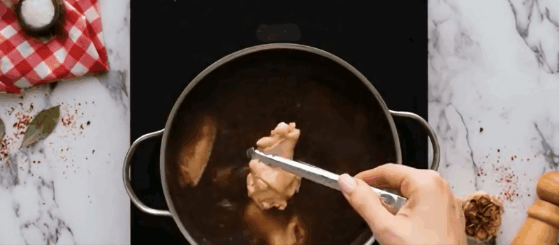Boiling chicken in seasoned water.