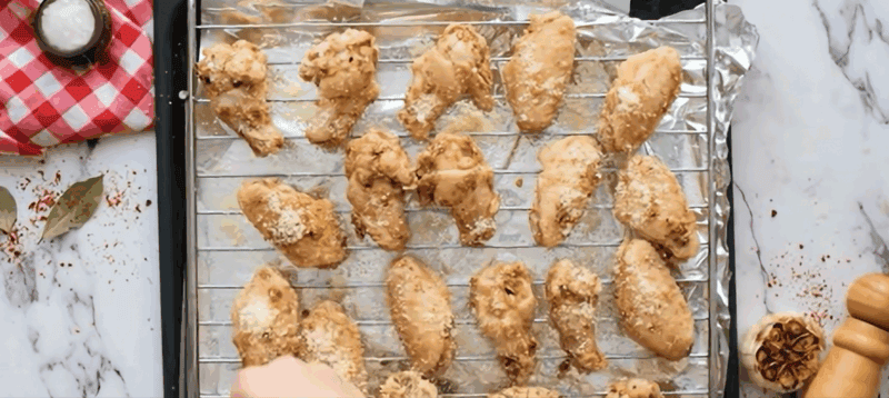 Garlic Parmesan chicken wings on a wire rack over a baking pan.