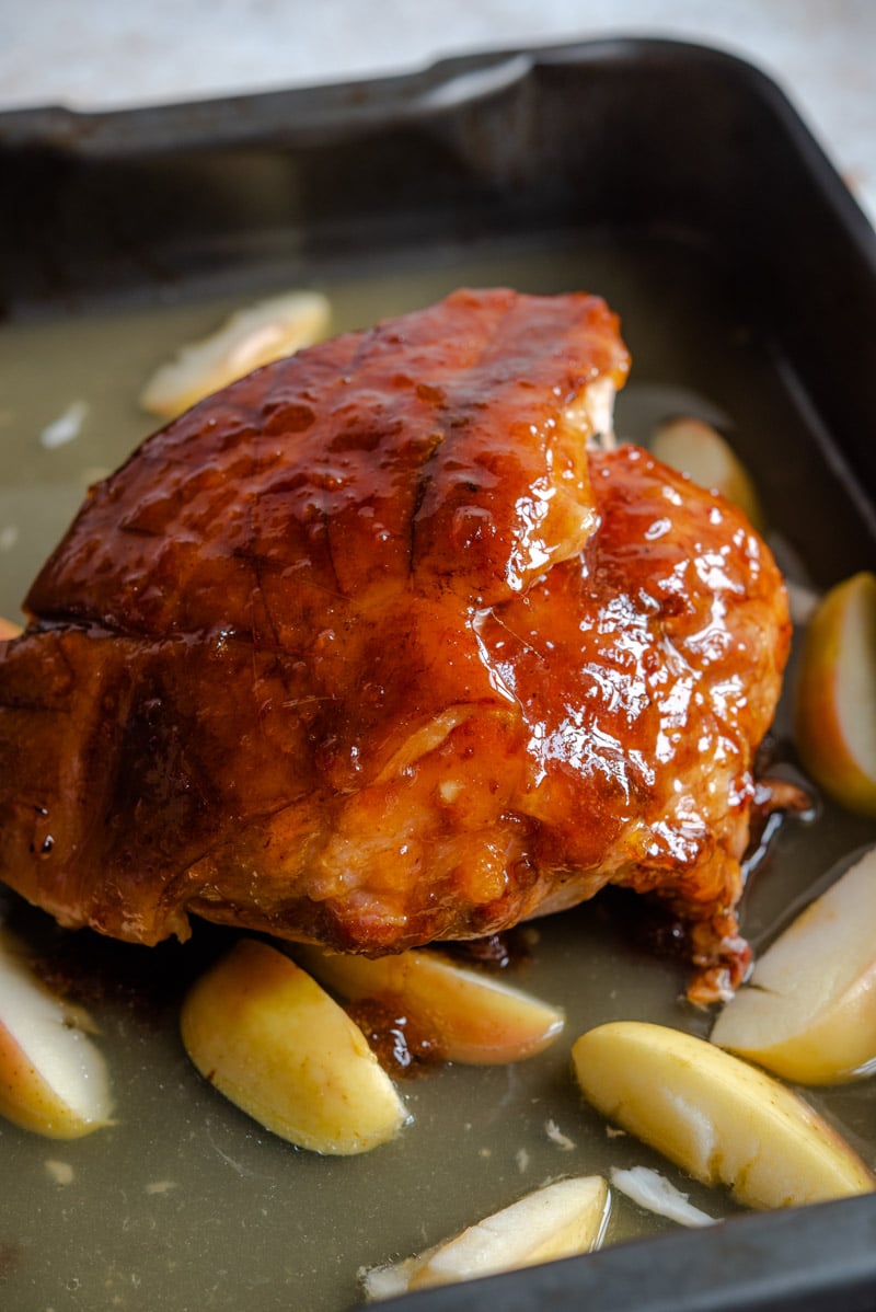 A glazed ham half way through cooking