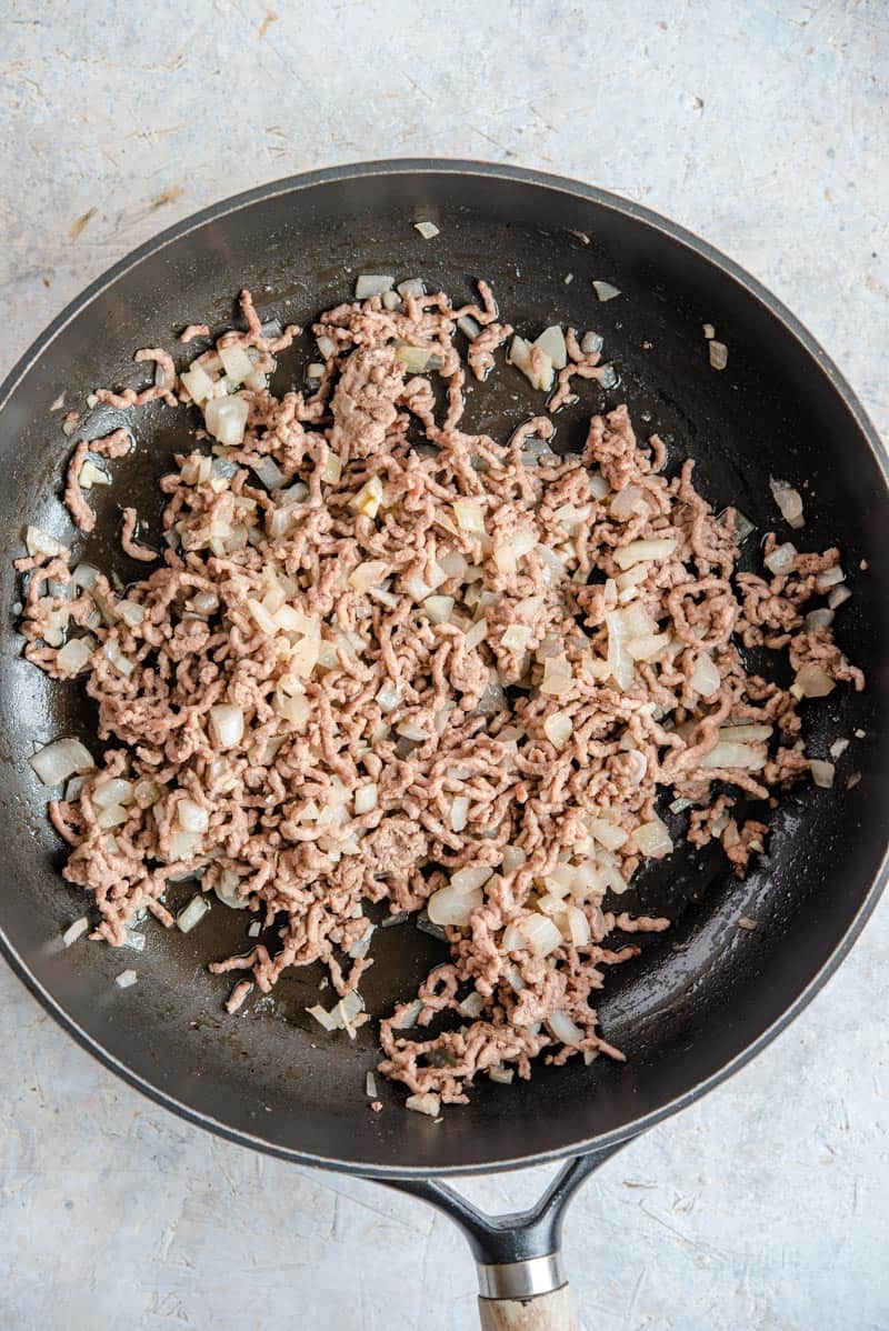 Beef, onions and garlic browned in a pan.