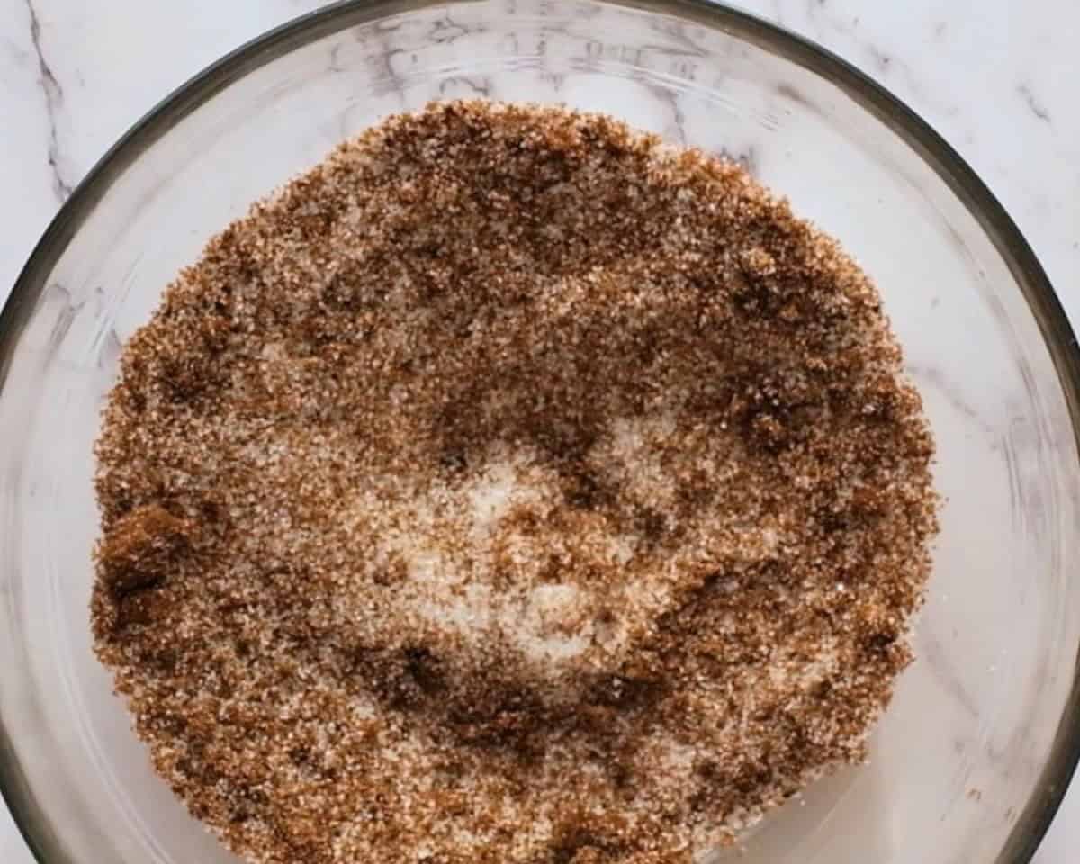 White and brown sugar in a glass bowl.
