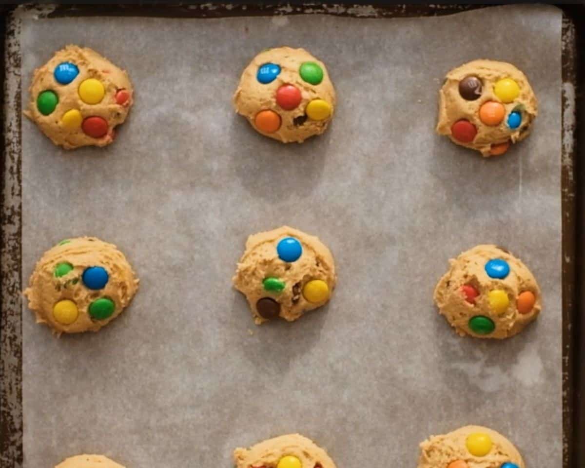 Portioning the cookie dough on a parchment-lined cookie sheet.