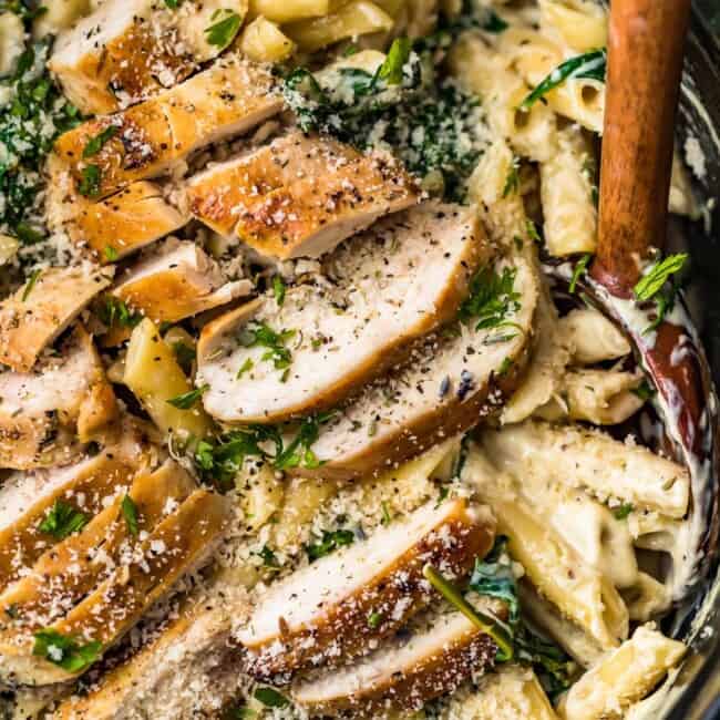 chicken florentine pasta in a bowl with wooden spoon