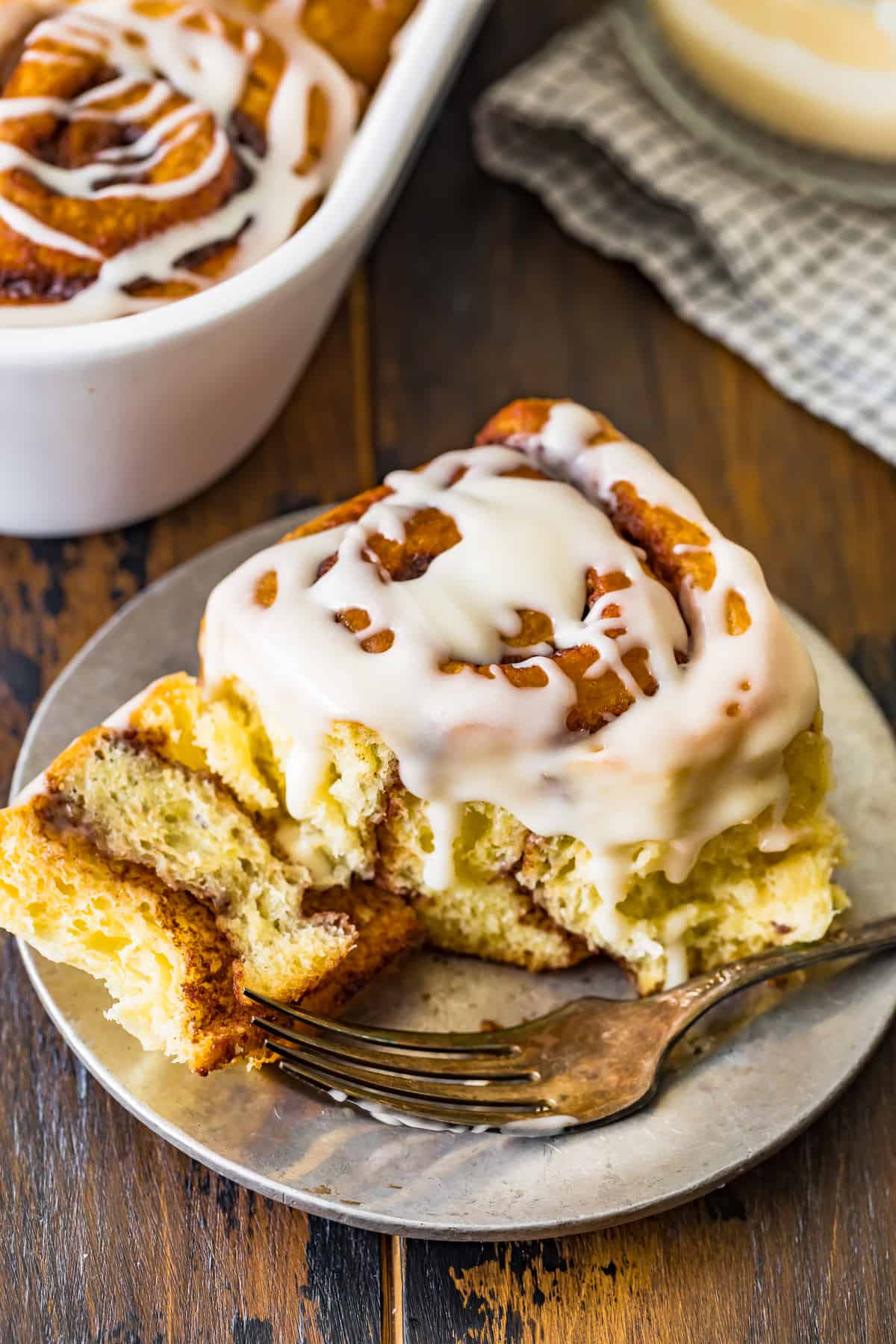 A cinnamon roll served on a plate with a fork