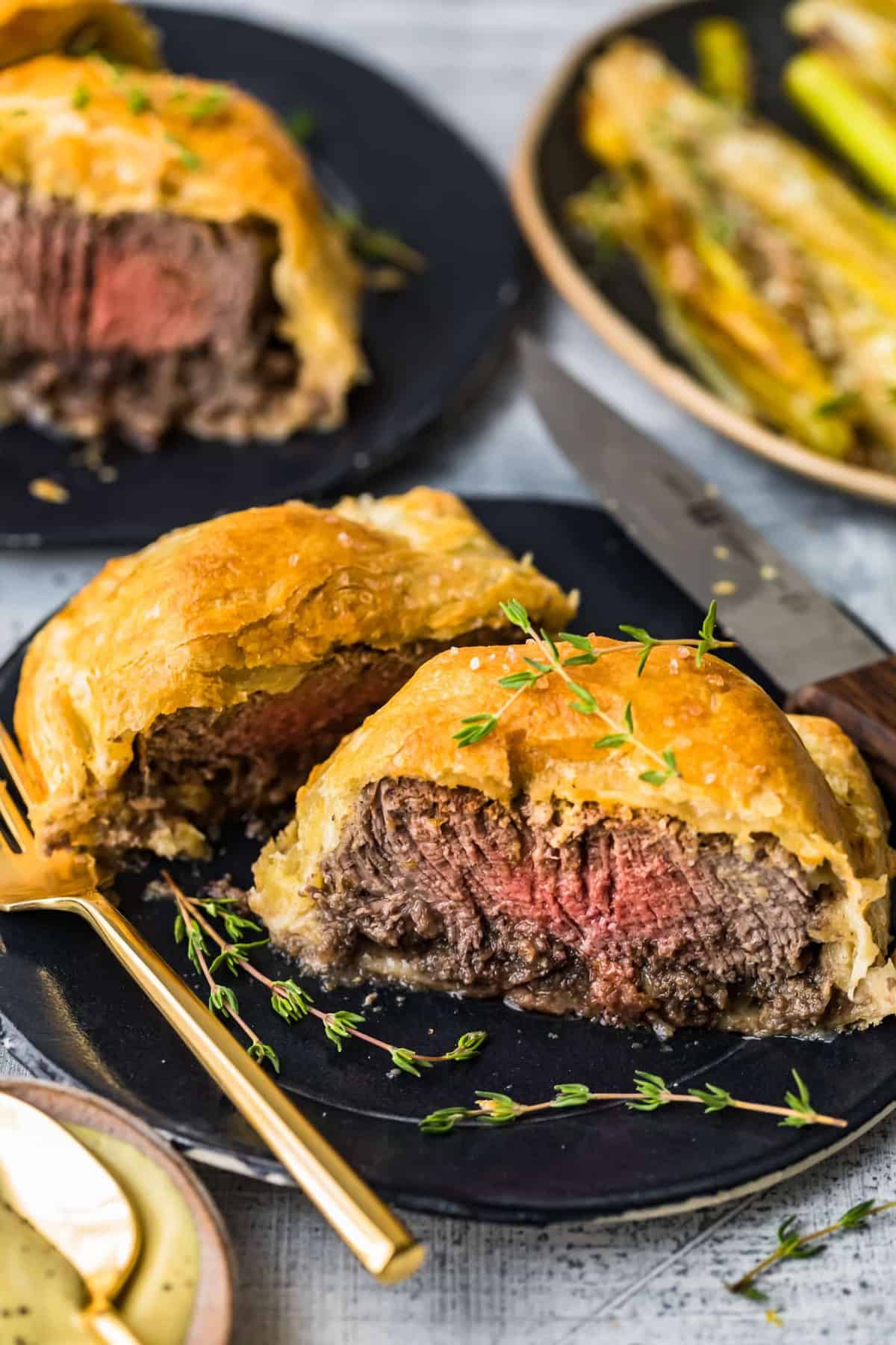 Beef wellington garnished with fresh herbs