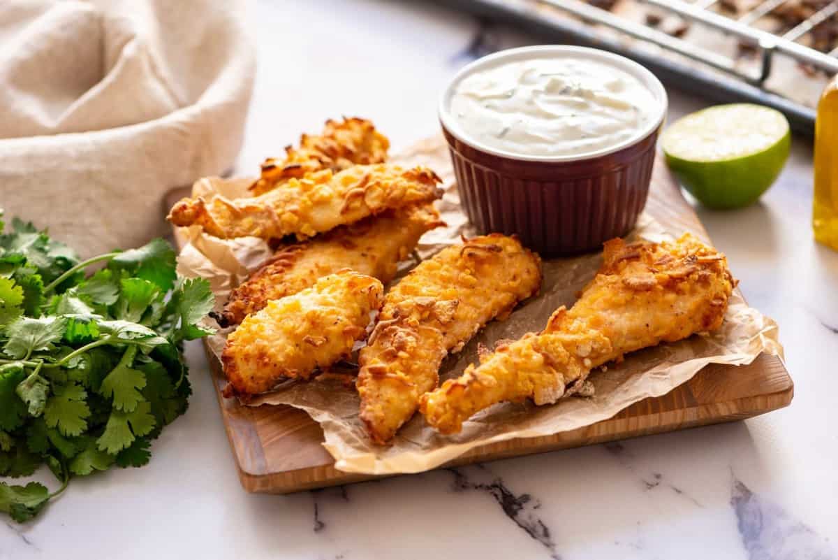 Crispy Baked Chicken Fingers served in a board with dip