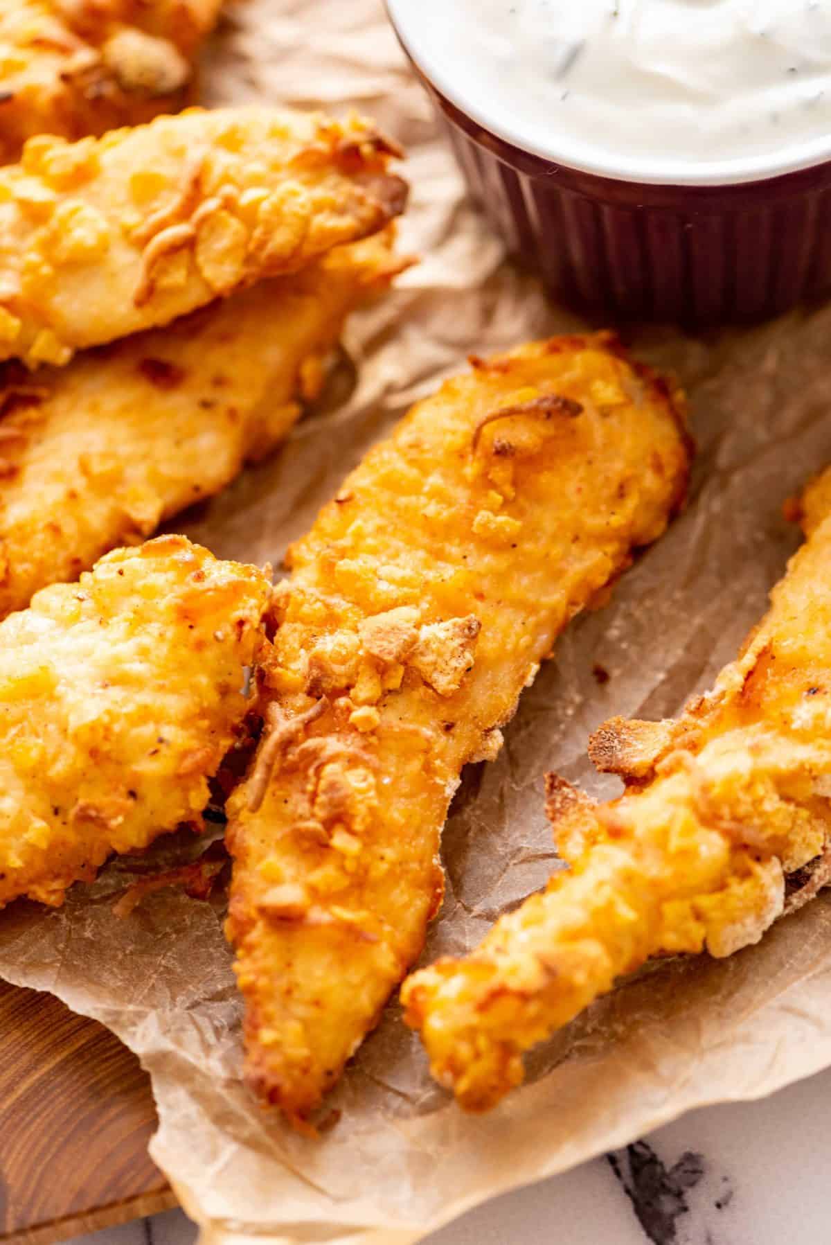 Close up of Crispy Baked Chicken Fingers on parchment