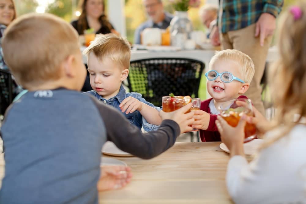 Kids putting cups together to cheers drinks