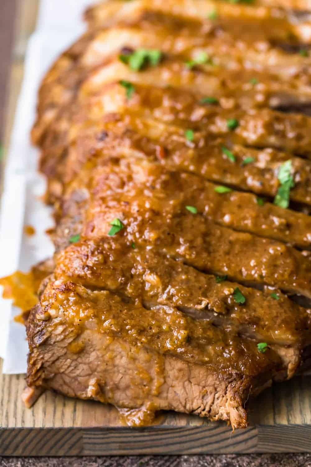 Sweet and sour brisket on a wooden chopping board