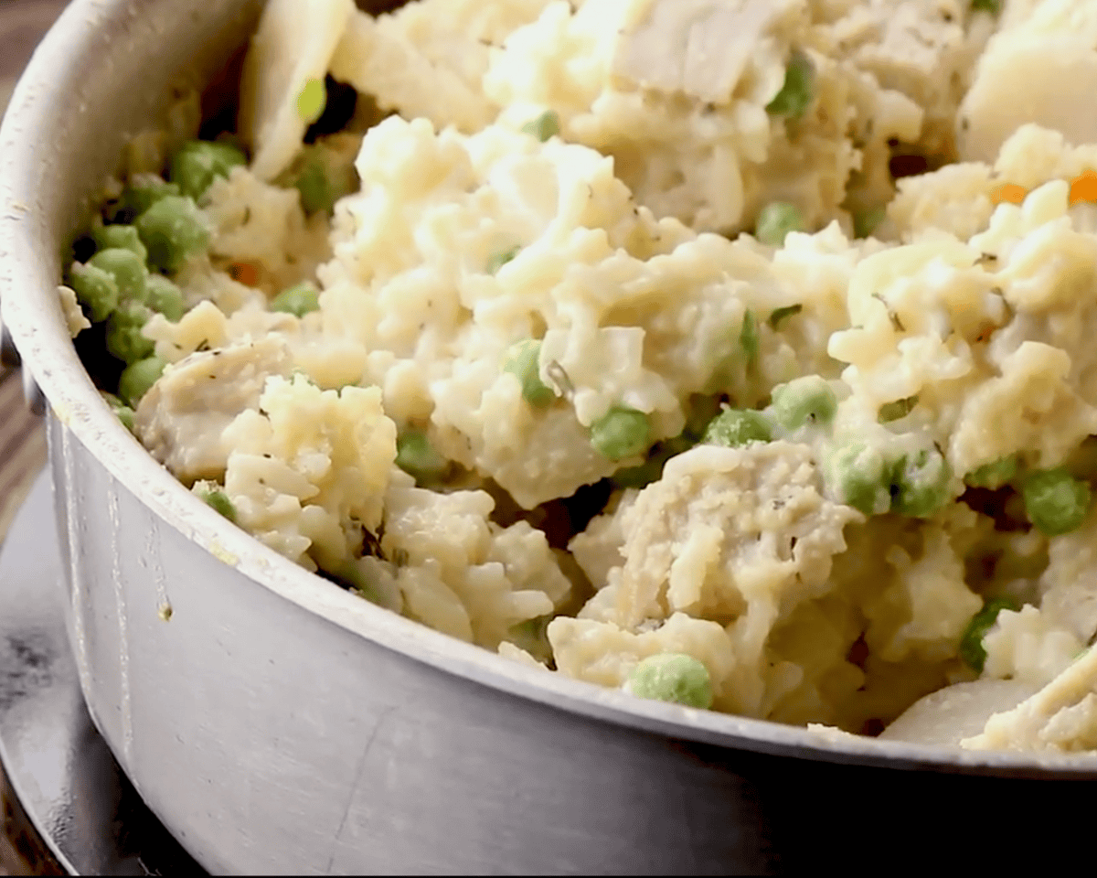 Turkey, peas, and rice combined in a creamy sauce inside the skillet.