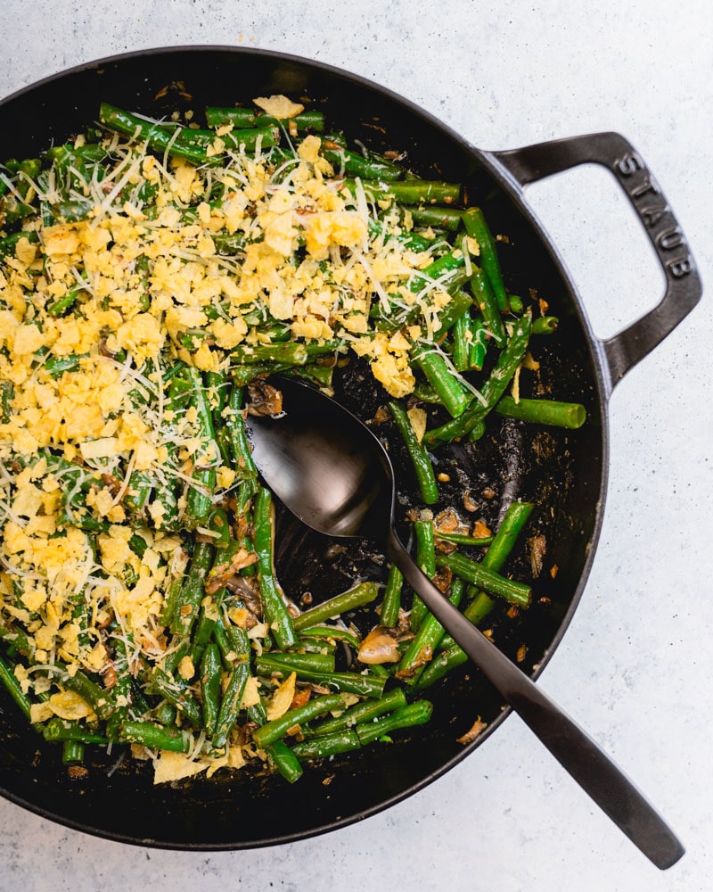 green bean casserole in skillet with spoon