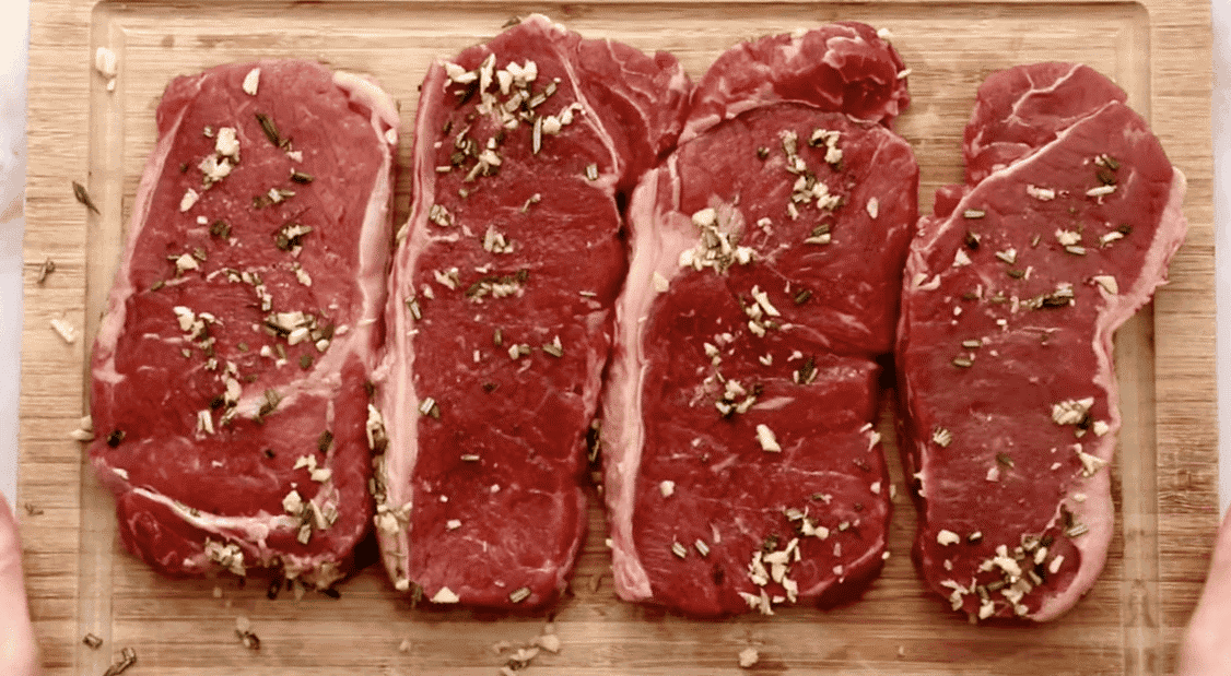 Raw steaks with seasoning. 