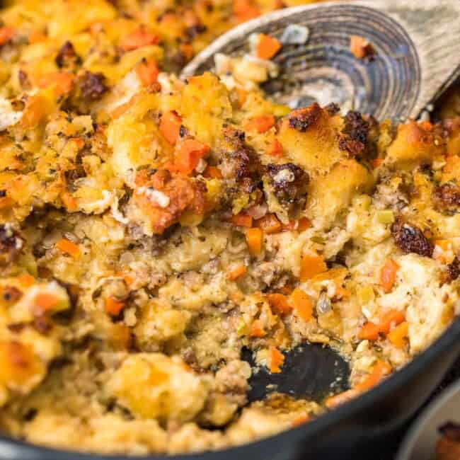 spoon scooping up sausage stuffing in skillet