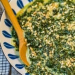 creamed spinach with toasted almonds in a bowl with spoon