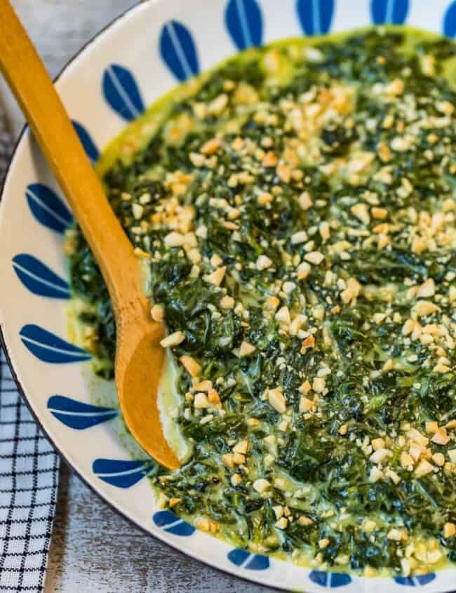 creamed spinach with toasted almonds in a bowl with spoon