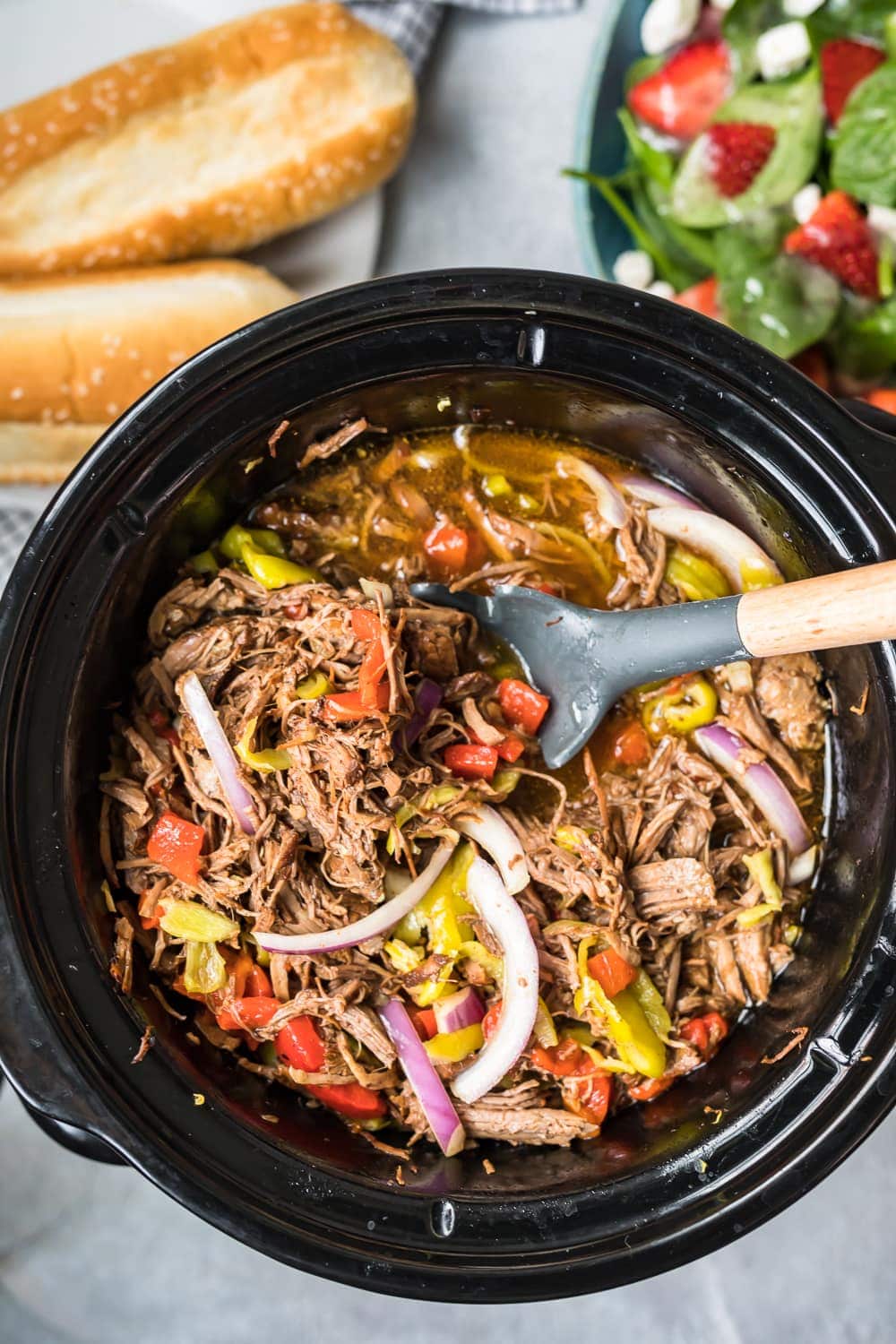 crockpot of italian beef, bread, and salad