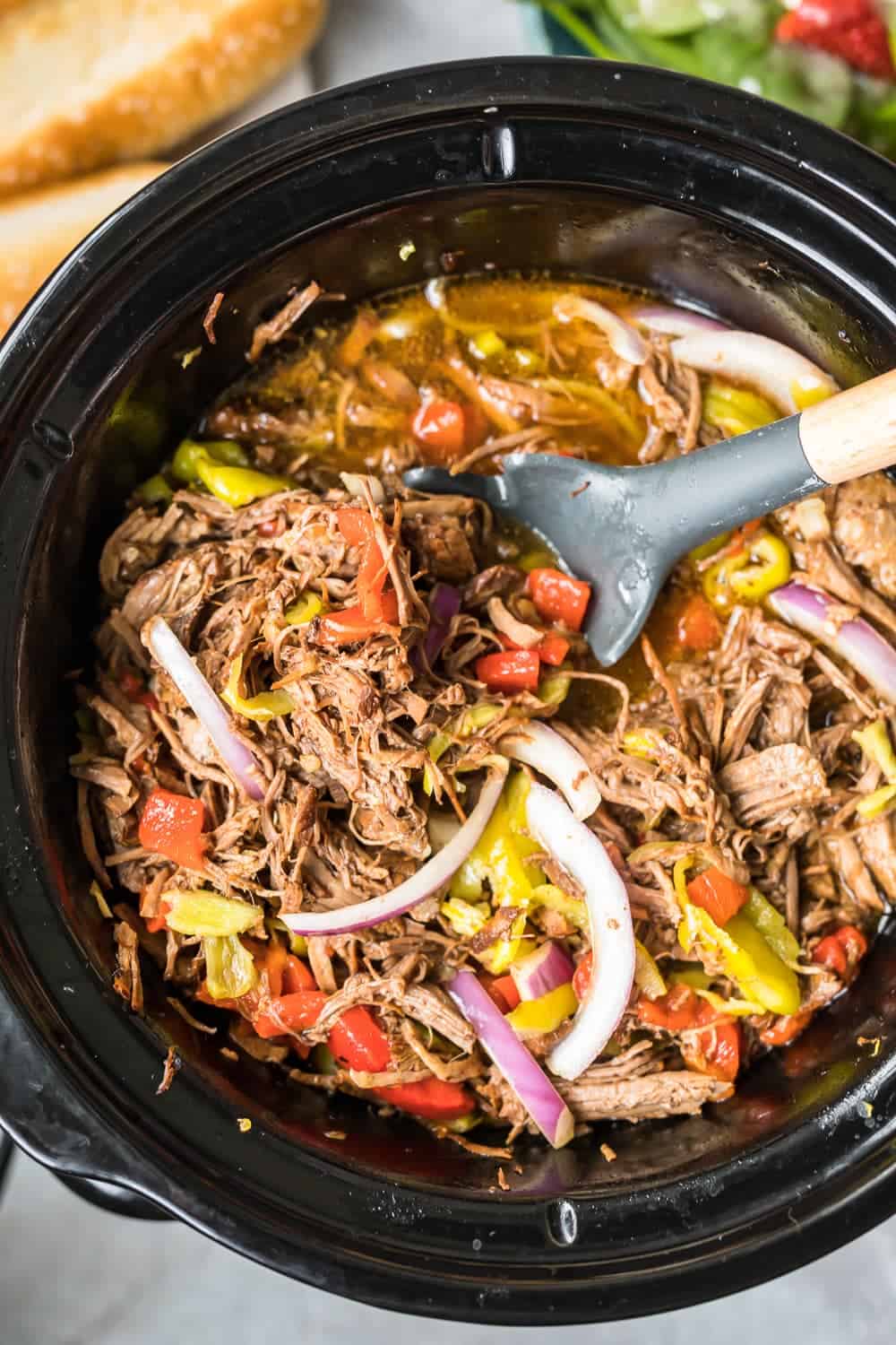 crockpot of italian beef being stirred