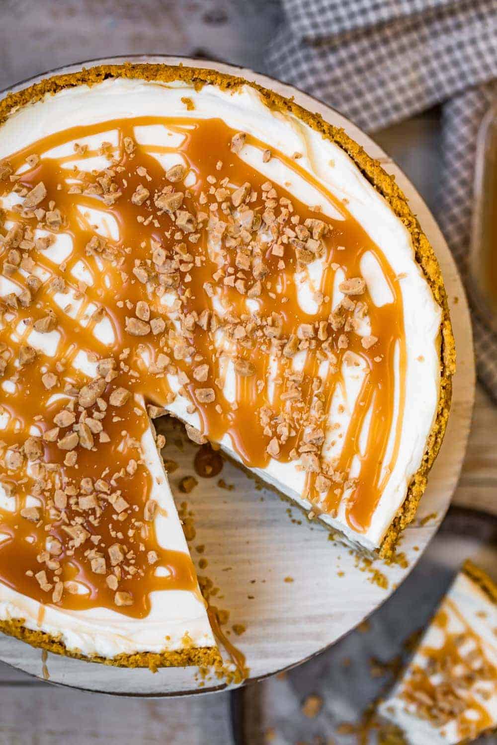 A cheesecake drizzled in caramel sauce