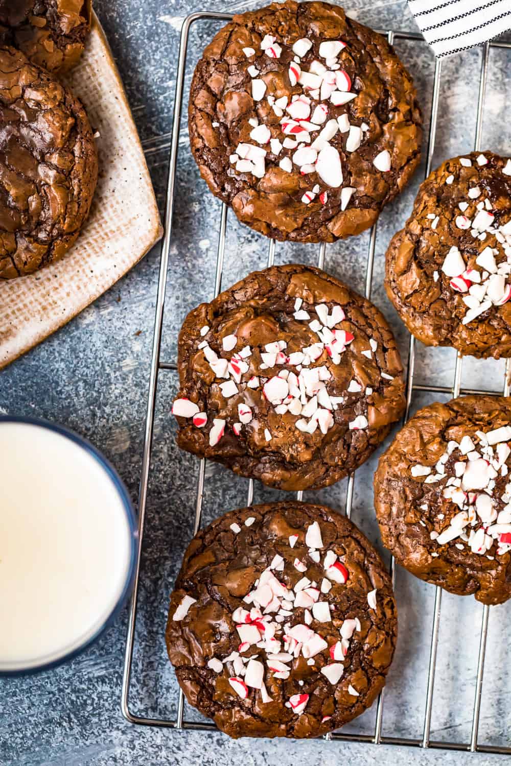 fudgy brownie cookies with peppermint candy on top on a cooling rack