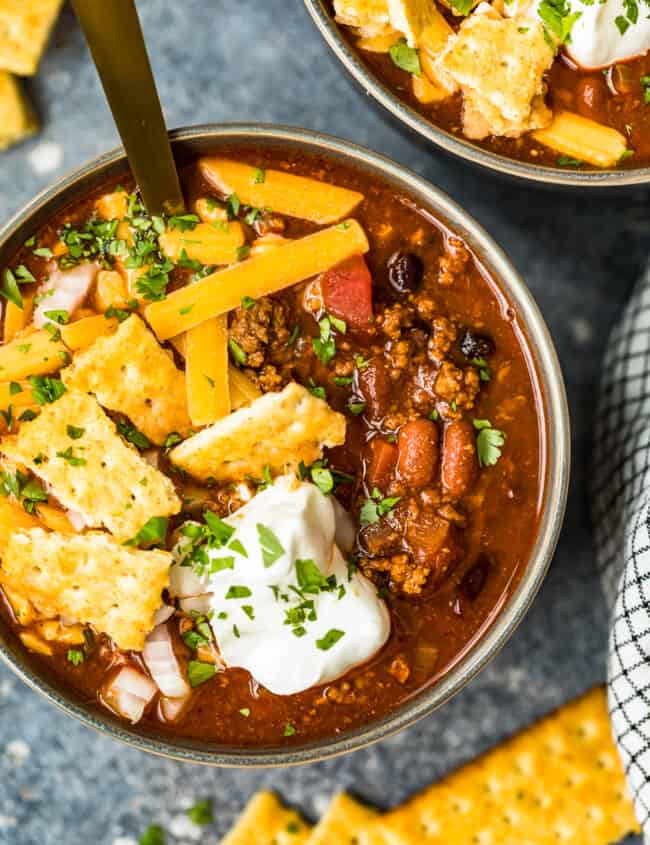 crockpot chili in a bowl with spoon with crackers