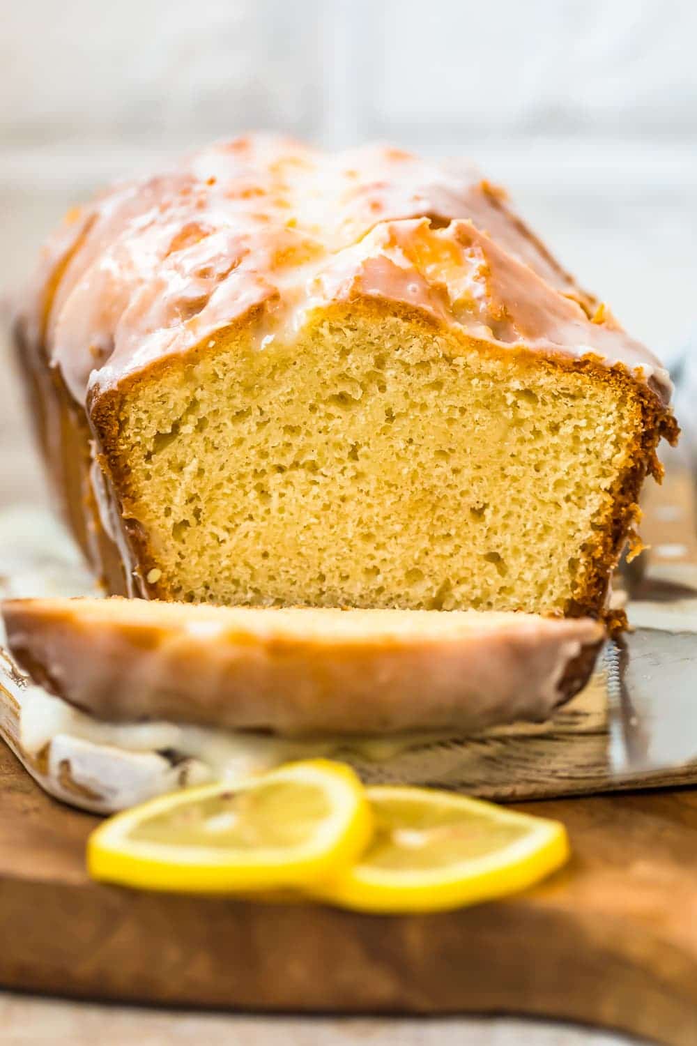 iced lemon loaf cake on a wooden cutting board