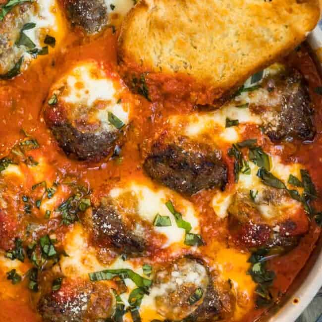 Meatballs in a tomato sauce served with bread and topped with Parmesan.