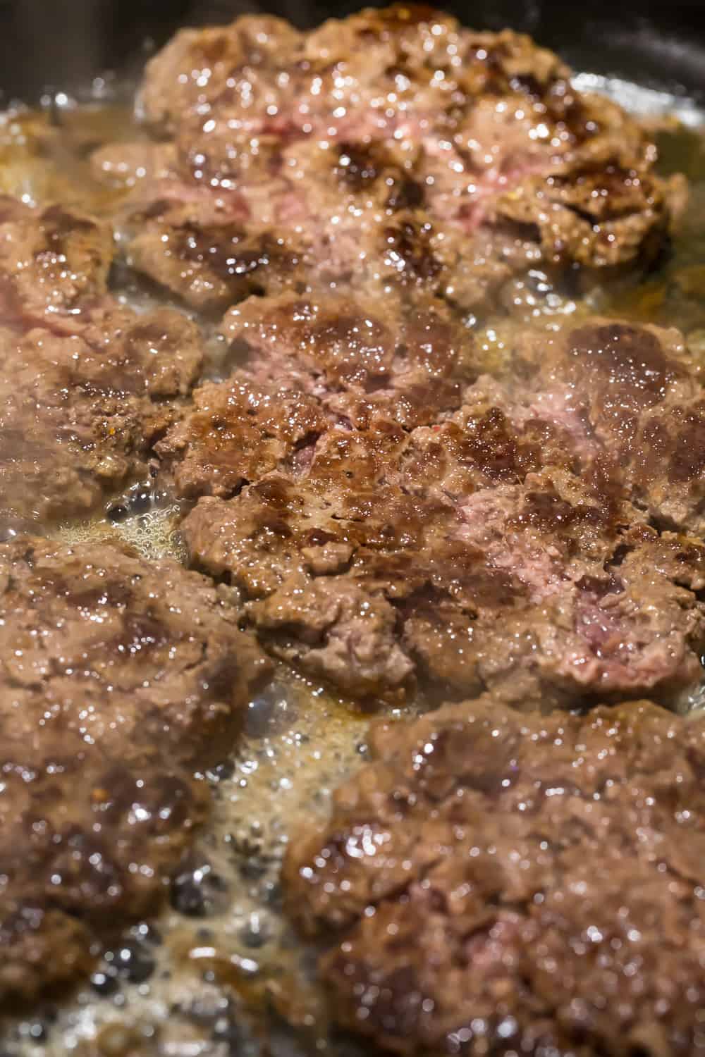 smash burgers in skillet
