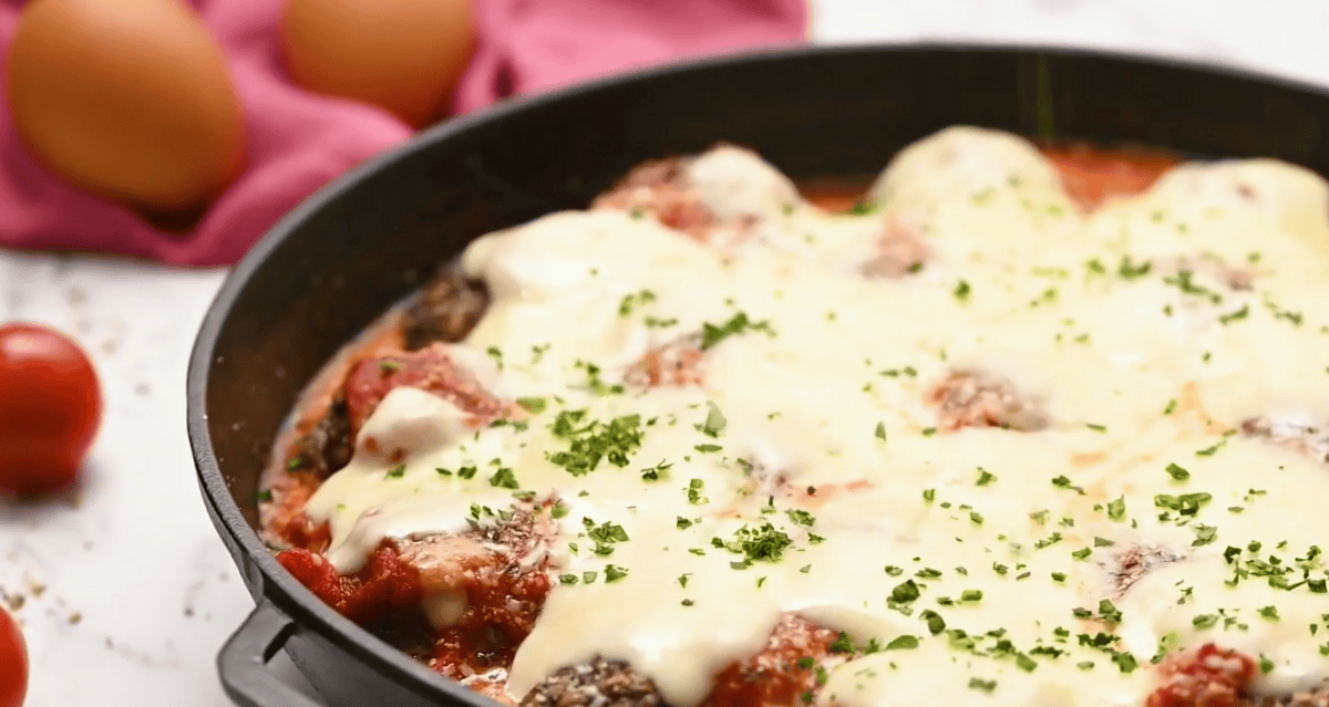 baked meatball parmesan in a skillet.