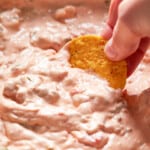 dipping chip into crockpot sausage cream cheese dip